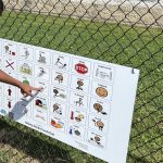 student pointing to playground communication board